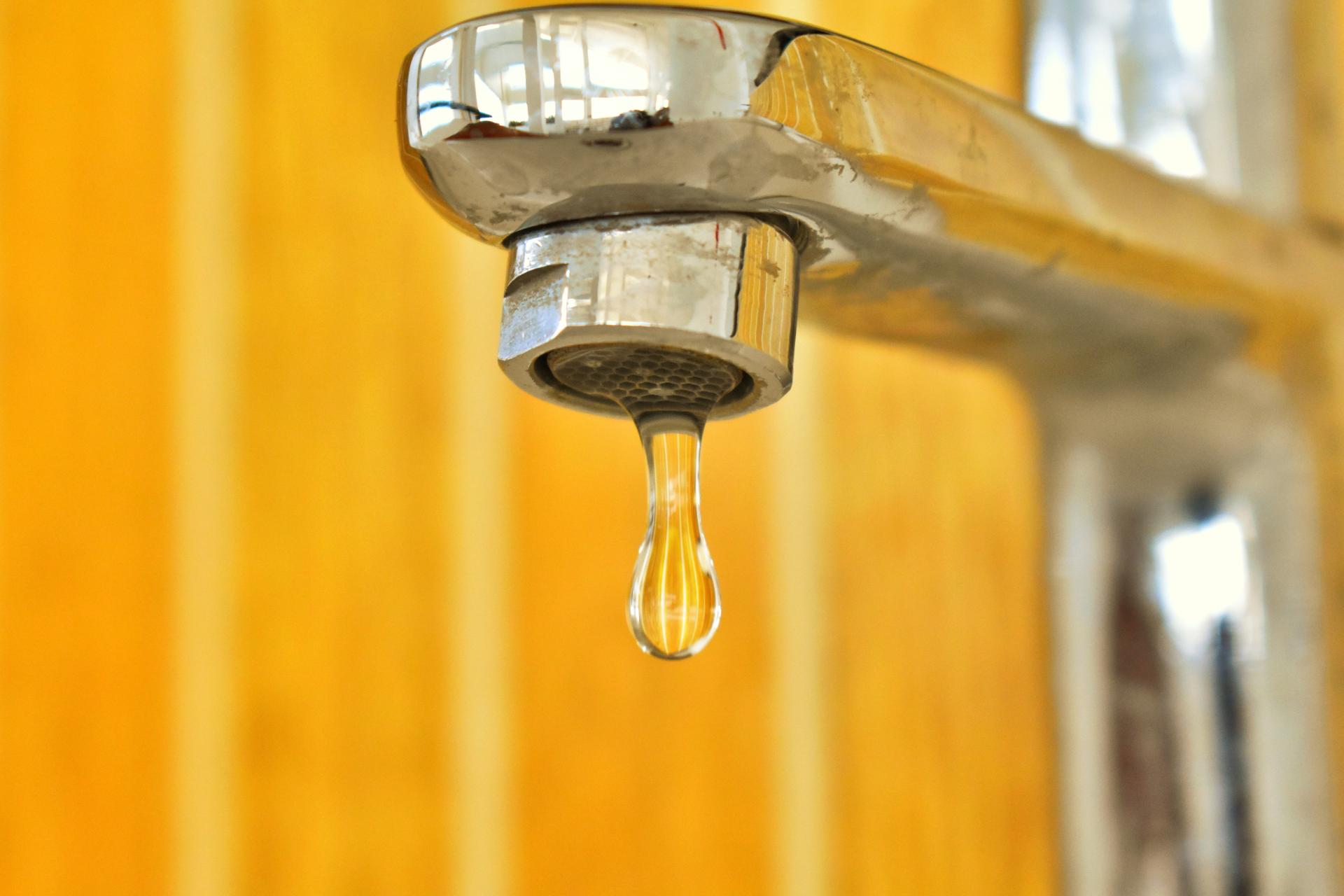 Wasserhahn, aus dem ein Wassertropfen tropft
