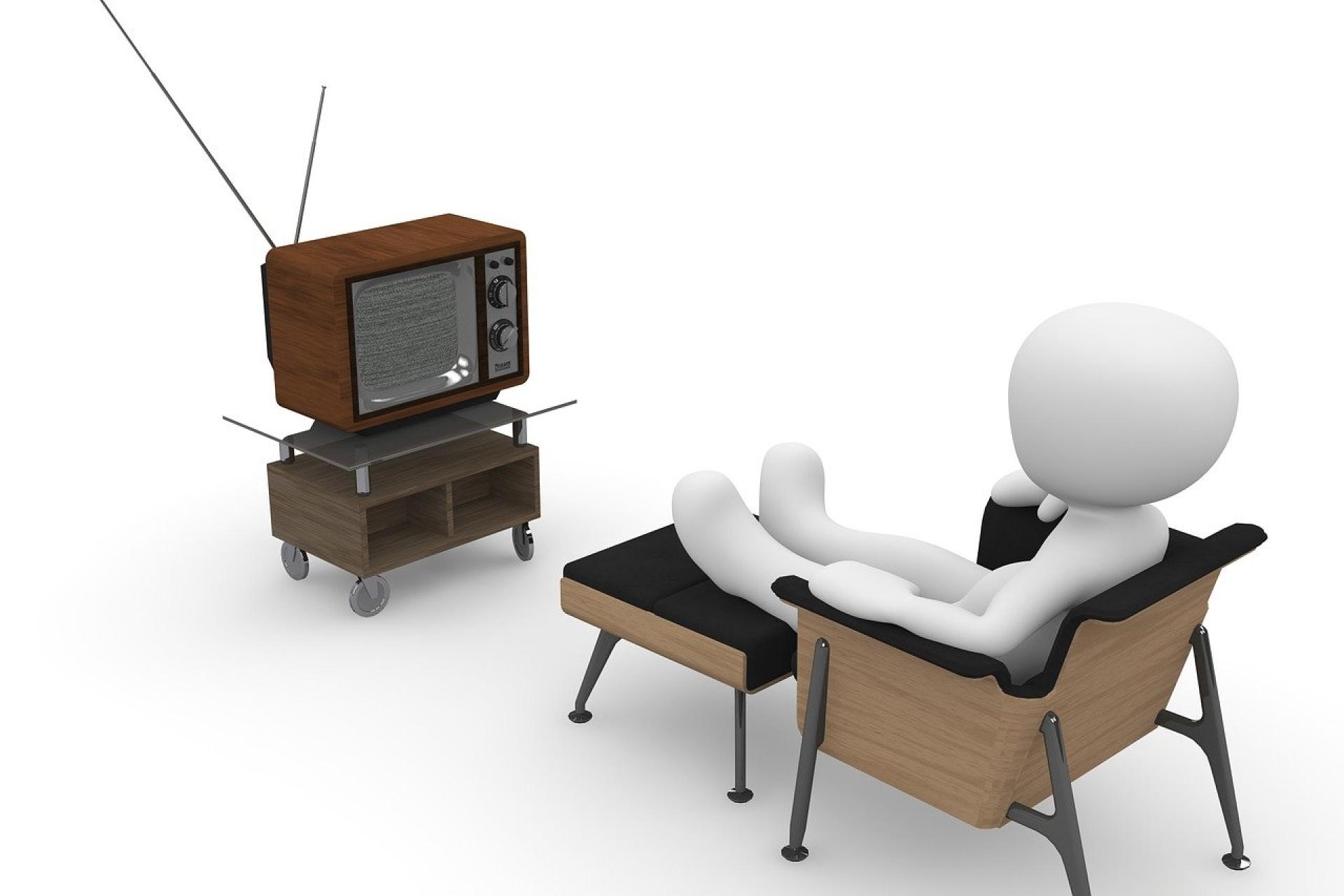 Figur sitzt auf gemütlichem Sessel vor dem Fernseher