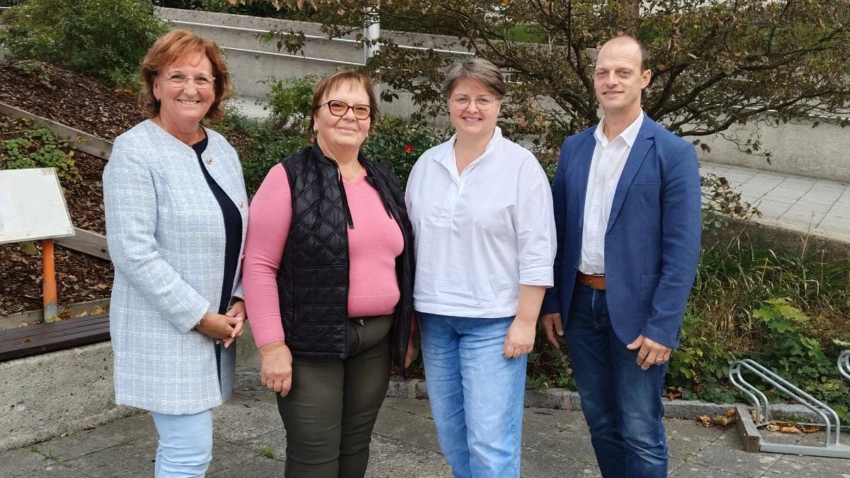 Vier Personen stehen nebeneinander im Freien, zwei Frauen im Vordergrund, zwei weitere Personen dahinter.