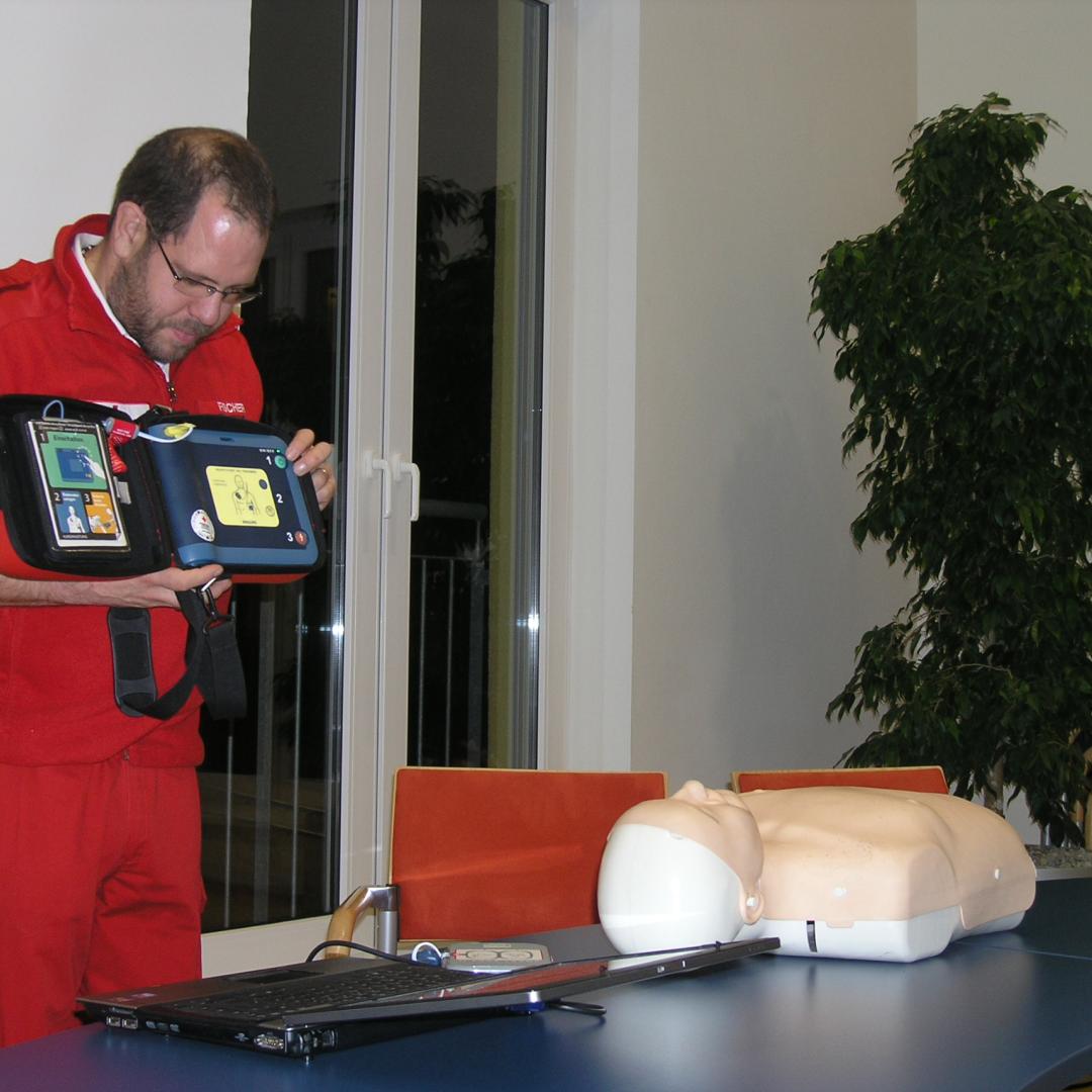 Sanitäter_zeigt_Defibrillator